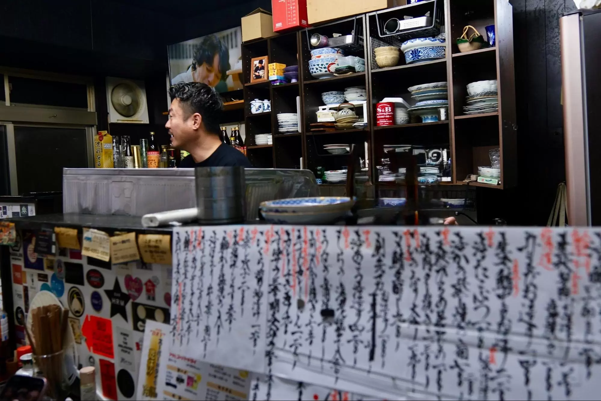 หลังเคาน์เตอร์ร้านอิซากายะ ไดสุเกะ เจ้าของร้านกำลังทักทายแขกอย่างอบอุ่น<br /> 