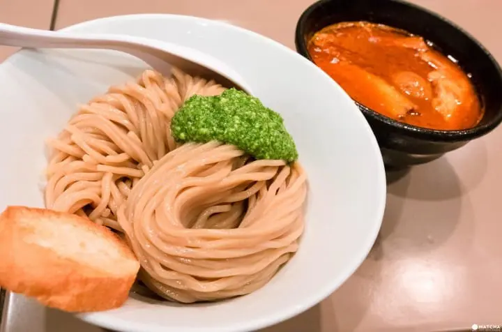 新宿一の行列店、五ノ神製作所の海老トマト肉と玉子入りつけ麺¥1180。海老とトマトが合わさることで、かなり濃厚でインパクトの強い味わいが特徴的。