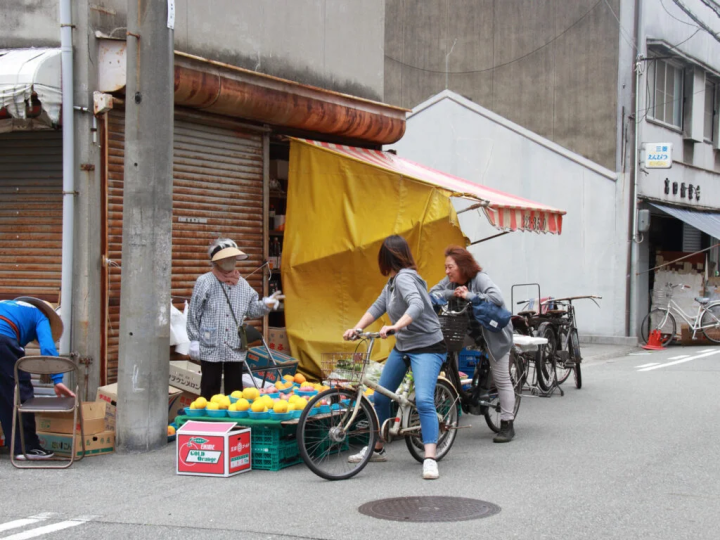 自転車のお客さんが軒先で店主とおしゃべり。旧市の日常です
