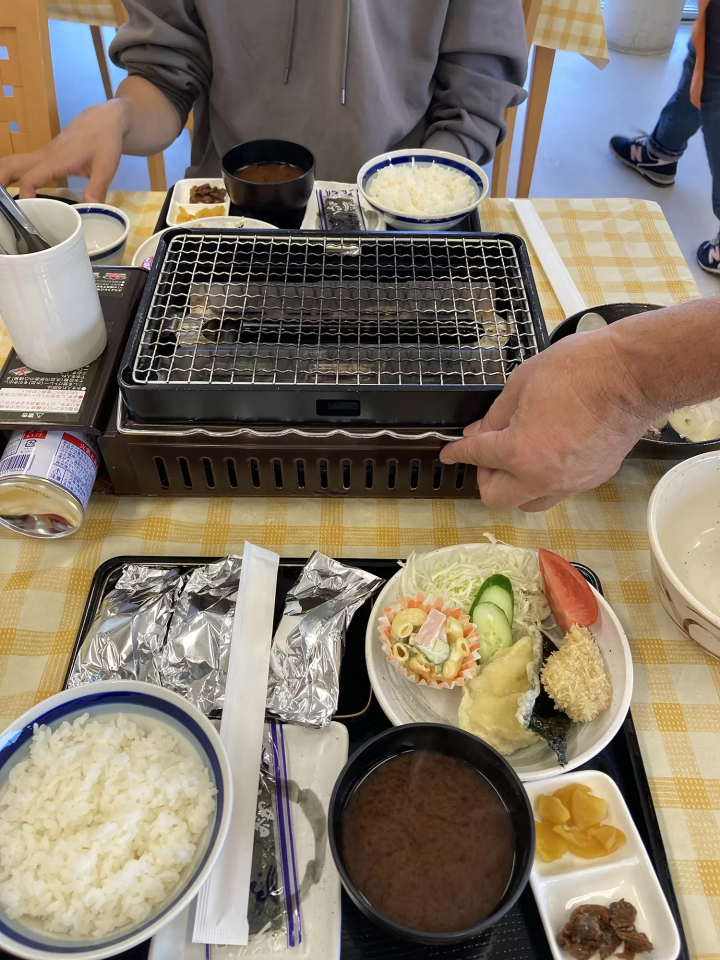 尝试吃蛤蜊菜肴。蛤蜊用铝箔包裹，然后在您面前的炉子上烤。 