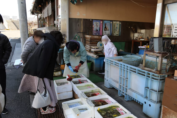 新鲜的贝类摆在我们面前，餐厅的工作人员正在问游客，“我们应该放多少公斤的贝类？” 
