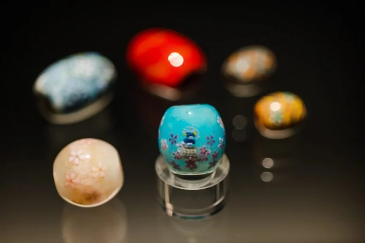 ทมโบดามะ = ลูกปัดแก้วตกแต่งมีรู เป็นที่นิยมเป็นอุปกรณ์เสริม<br>