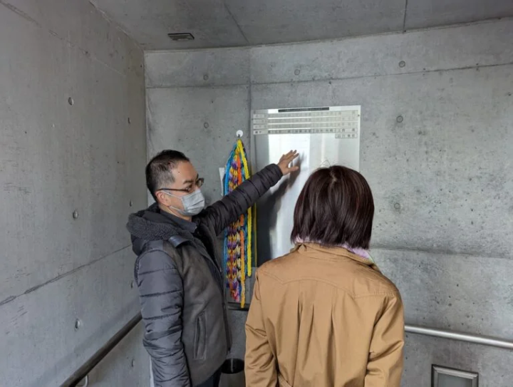 คุณมิยาโมโตะ (ภาพซ้าย) กำลังนำทาง ``พื้นที่ทำสมาธิ'' ใต้ดินของอนุสาวรีย์เพื่อการรำลึกและการบูรณะใหม่<br>