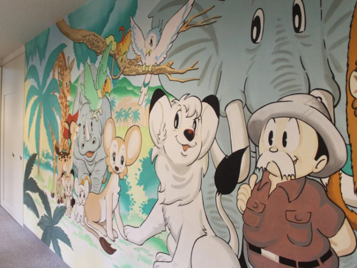 Exit the hall and turn right. The murals along the corridor are a popular photo spot.<br> 