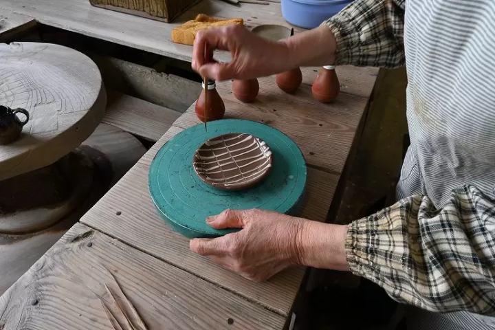 ▲丹窗窯第8代市野茂子的手工工作。圖案是帶領民間藝術運動的英國陶藝家伯納德·利奇直傳的滑鞋 
