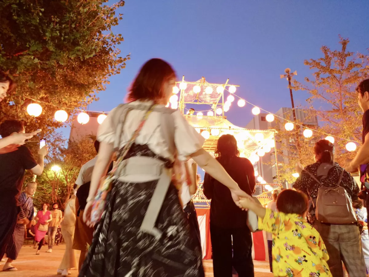 (Bon Odori dance. A stage is set up and the atmosphere is lively.)
