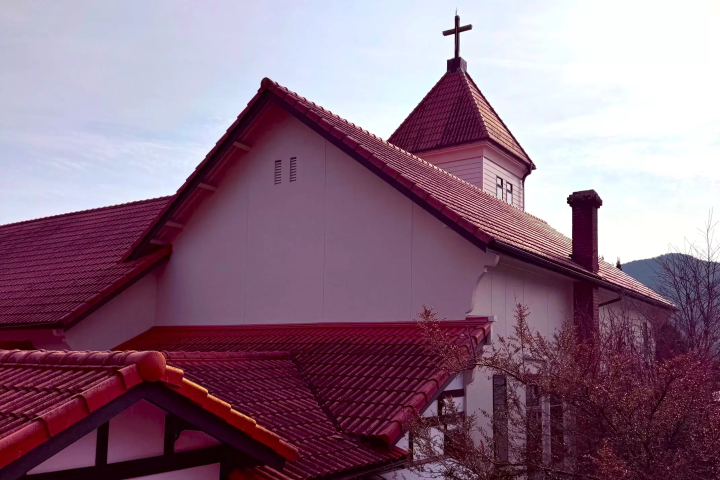 Built in 1926 (Taisho 15), Unomachi Kindergarten and Unomachi Christ Church is a distinctive building with a turret topped with a cross, a red roof, and white wooden walls.<br> 
