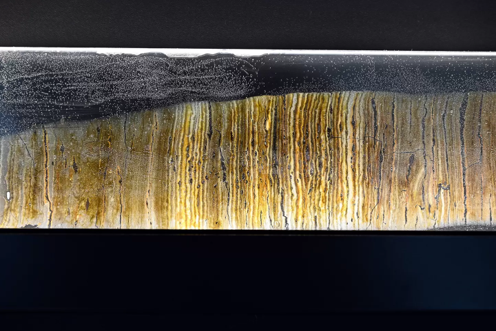 This stained glass piece is made from varves that have been sliced ​​and polished using special techniques to be thin enough for light to pass through, then set into glass. The varves of Lake Suigetsu record the history of climate change and natural disasters from approximately 70,000 years ago to the present, and the pollen contained in the varves not only reveals the past vegetation of the surrounding area, but also serves as a ruler that can accurately determine the age of fossils and artifacts excavated around the world. 