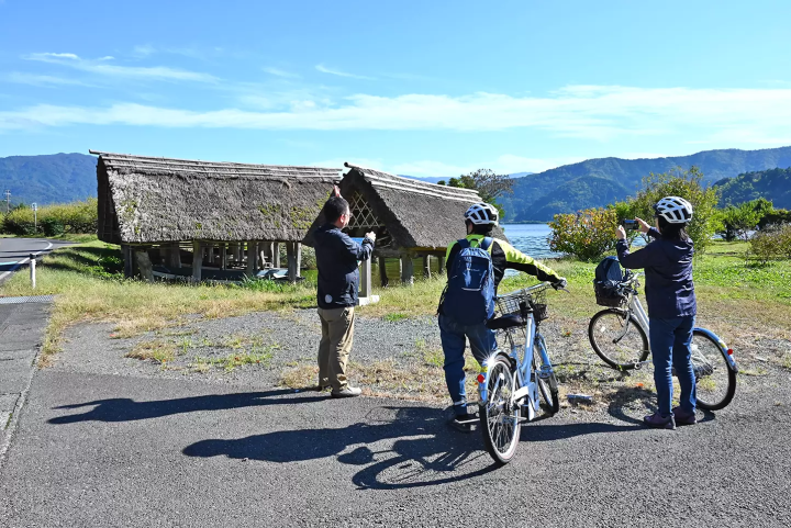 The thatched-roof buildings scattered along the lakeside are boathouses that housed boats used to travel between plum orchards and rice paddies and to ship harvests. 