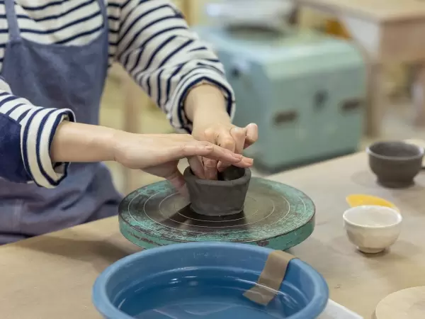 Place the clay on the potter's wheel and even out the thickness while imagining the shape you want to create. 
